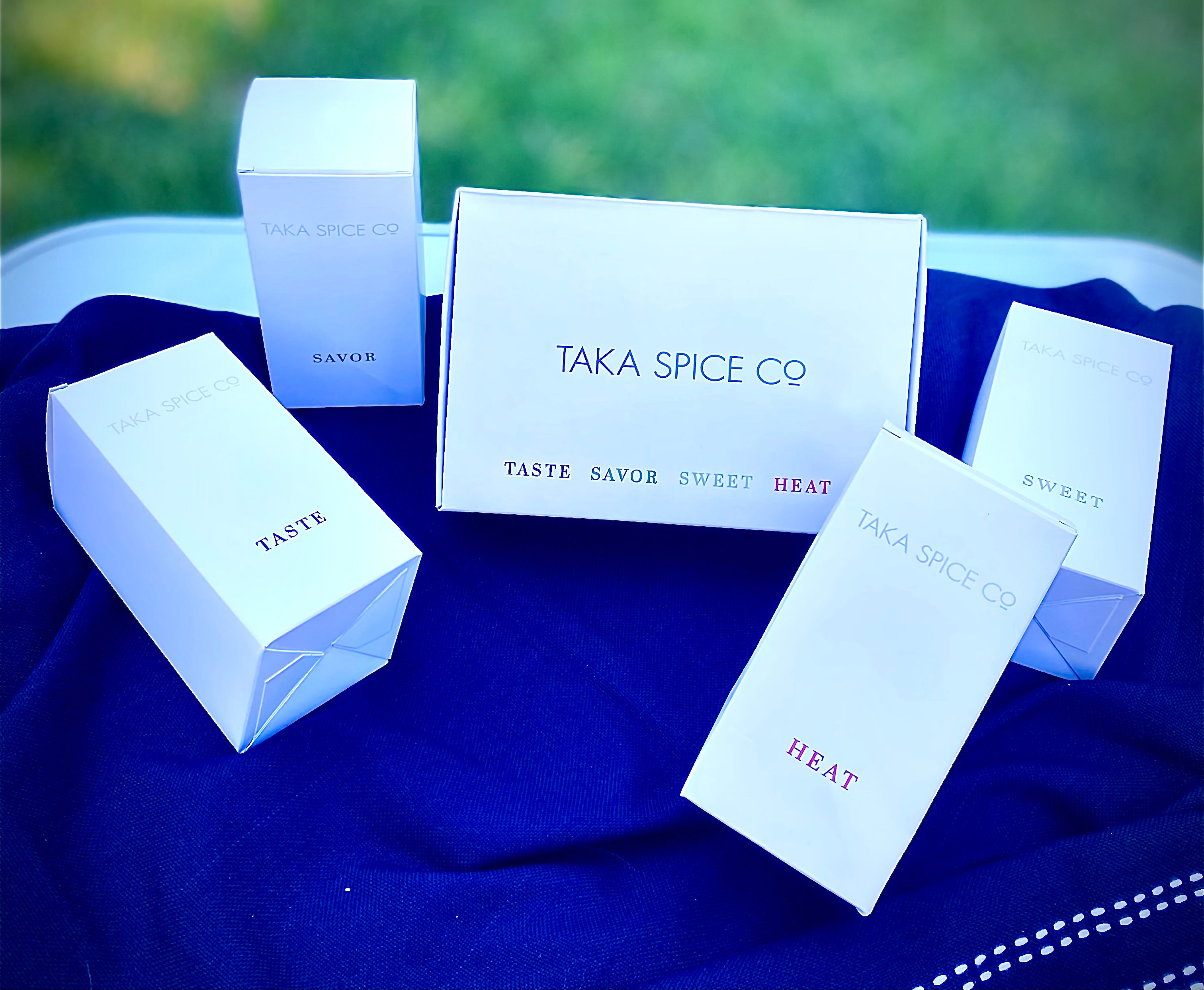 taka white product boxes layout on blue cloth